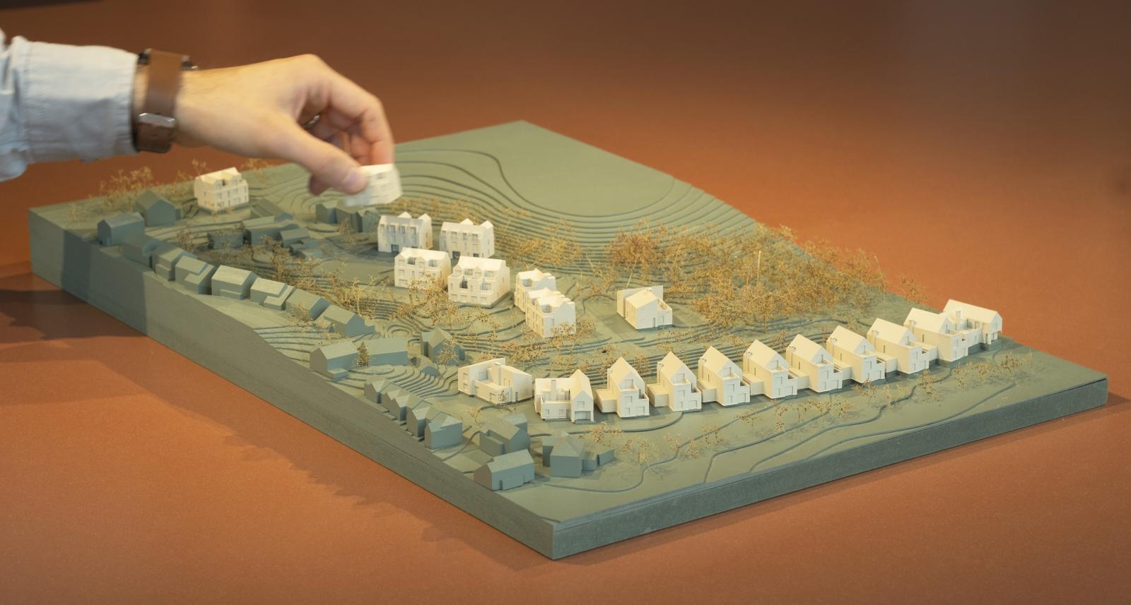 Booths Bank Farm, 1:500, Site Context Model

Produced for a pre-application meeting with Salford City Council, this context model was created to understand the site's levels and the relationships between the proposed homes and neighbouring properties. Rather than this model representing the final design, we designed it to allow each house type to be swapped or replaced as the homes' designs developed in response to team, client, and councillor comments. With Shaw Brook running parallel to the development site, it was essential that the site levels be communicated clearly, as drawings struggle to show this relative to other areas. Furthermore, it was important to show the proposed landscape strategy: maintaining the majority of trees currently on the site's perimeters, establishing links to Alder Wood to the east and a public right-of-way to the south, and creating a woodland play area at the heart of the project within a proposed attenuation basin.

Laser Cut Plywood and SLA 3D Print, Spray Painted, Seafoam Trees

Made by Saul Bunyan, Architectural Assistant and Modelmaker, additional 3D printing by Dante Hall, Senior Architect