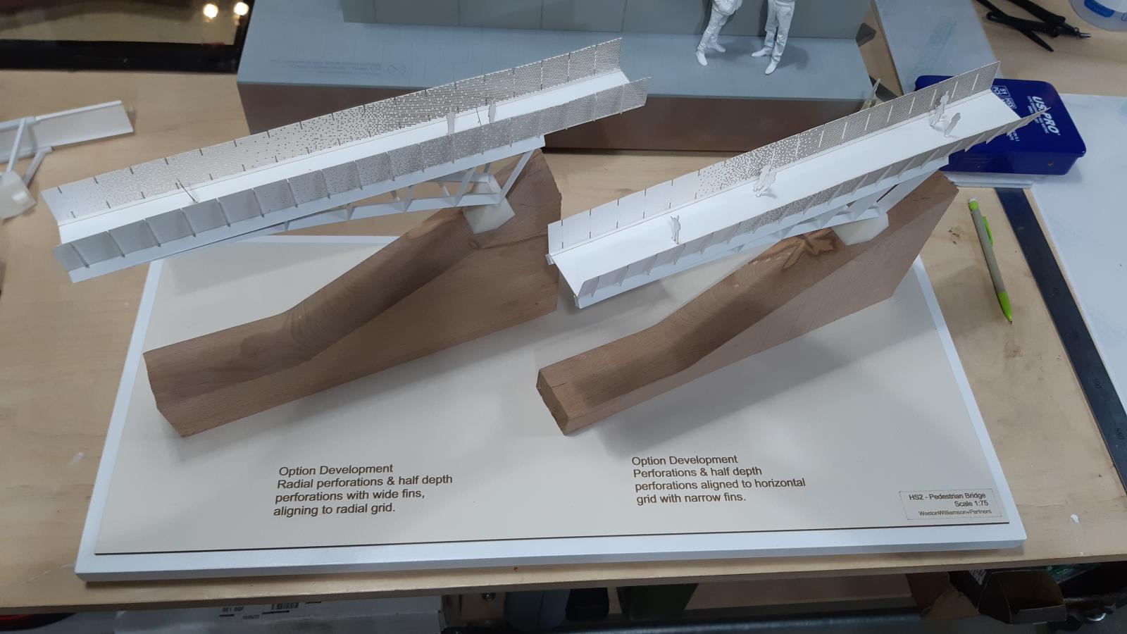 Pedestrian Bridge Study Size / Scale = 1:75

Lots of physical models were developed for this project. The footings, structure and parapet were all modelled many times and their design experimented with by both the architectural team and the model team. Do to this efficiently and quickly the use of rapid prototyping techniques were utilised. 3D printing was used for the structure and footings first fixing the bridge into hand carved foam. The laser cutter was then used for producing the intricate parapet options. This enabled many different iterations to be tested and simply cut in thin card. It was only after this process had been followed and many different components had been developed that these models were put together, from parts of the most successful tests, as a kind of reference model. The final design has still moved on a little from here. 

Materials: Beach Timber, Card, Stainless Steel, PLA Filament, Finishing Wax, Painted Plywood Base. Techniques: Traditional Machining, Laser Cutting, 3D Printing, Acid Etching.

Maker: Toby Loughton, Head of Modelmaking