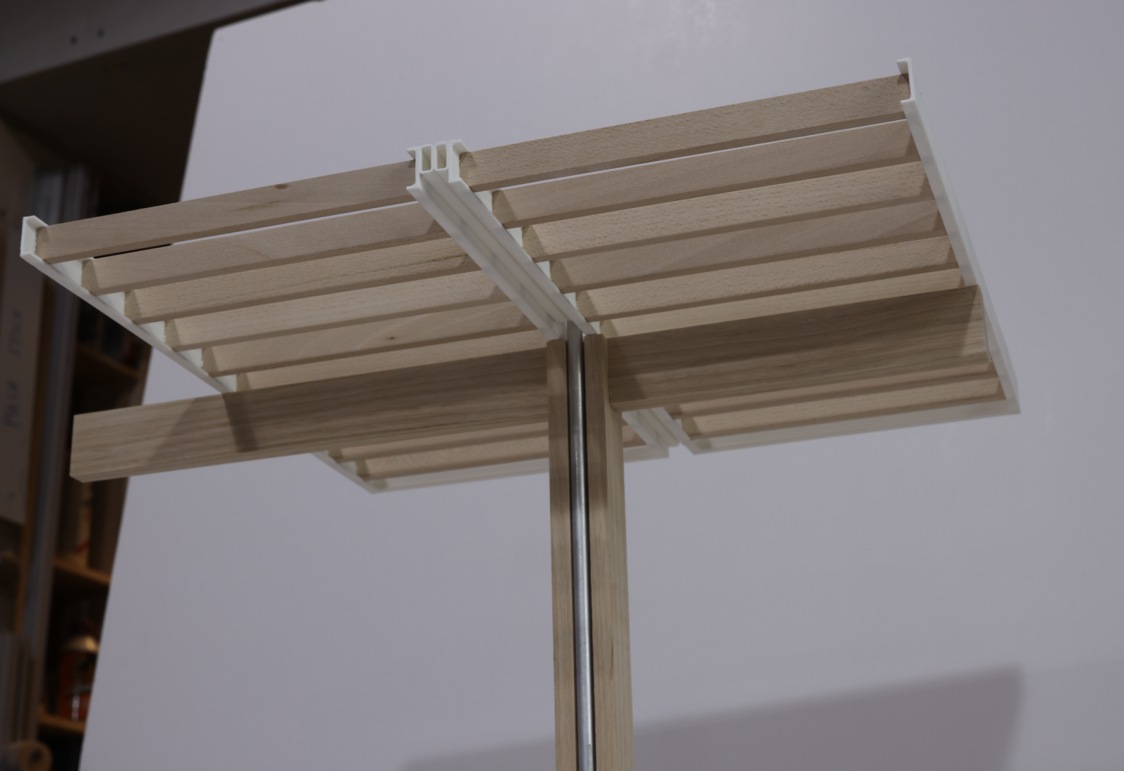 Canopy Design Study / Scale = 1:20

This was the second study model we completed for the design of a station canopy. The first iteration of the design was approached in a linear way. The thinking being that; rectangular cassettes/panels (with a steel outer frame and timber cross bracing) could be manufactured off site, travel to site in whole pieces and then be assembled together into the whole canopy in situ. When making the model we noticed that the deflection of these panels was quite considerable (about 3-4mm at scale) suggesting that at 1:1 it could be quite considerable. We were fairly convinced that we could improve this structurally and in doing so thought we could also improve the aesthetics of the sofit too. This diagonally braced panel design was conceived. These models were made at an early stage of concept design, used for internal development; though they were also shown to client to help explain our intent and show our current progress. 

Materials: Ash & Maple Timber, Acrylic & Mirrored Acrylic, PLA Filament, Aluminium Tubes, Plywood Base, Stainless Steel Fixings. Techniques: Traditional Machining, Laser Cutting, 3D Printing.

Maker: Toby Loughton, Head of Modelmaking