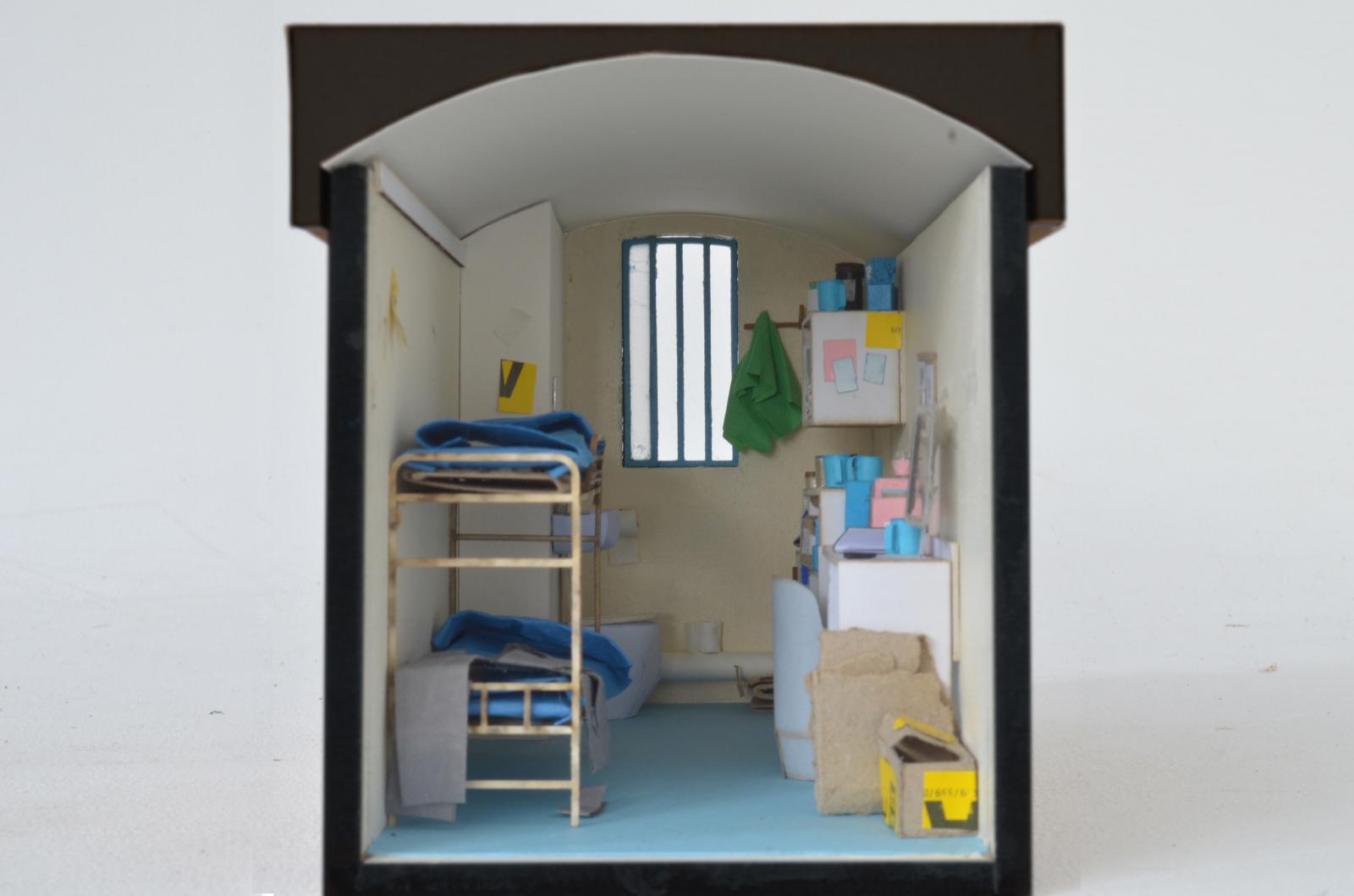 Facing a Crisis: HMP Wandsworth Cell / 1:20 / Ethnographic model of typical prison cell and objects

This model was developed for a filmmaking and research project in HM Prison Wandsworth in London exploring how the prison environment, everyday objects and spatial conditions shape the mental health of prisoners and staff. The work consisted of a scale model of a prison wing and 10 individual cells, designed to be used directly by participants as tools for discussion and reflection.
The model enabled prisoners to recreate their own living spaces in miniature—arranging furniture, placing personal items and adapting the cells to mirror their daily routines and coping strategies. Working at scale allowed participants to describe their experiences more openly, using the model to show how spatial pressures, noise, confinement, or treasured belongings influence their wellbeing. These exchanges formed the basis for a film examining the factors that contribute to mental health emergencies in prison, to be screened for prisoners and staff.
In Facing a Crisis, the model functioned both as a communication device and a method of engagement. It offered a neutral, creative space within a highly constrained environment, allowing conversations that are otherwise difficult to initiate. The project extends ongoing research into how modelmaking can support participatory dialogue with marginalised groups, revealing lived realities that are often hidden, sensitive or hard to articulate.

Laser cut MDF, card, paper

Ecaterina Stefanescu and Sam Eadington (modelmakers), with input from Jas Pitt, Inside Job Productions and a group of HMP Wandsworth prisoners.