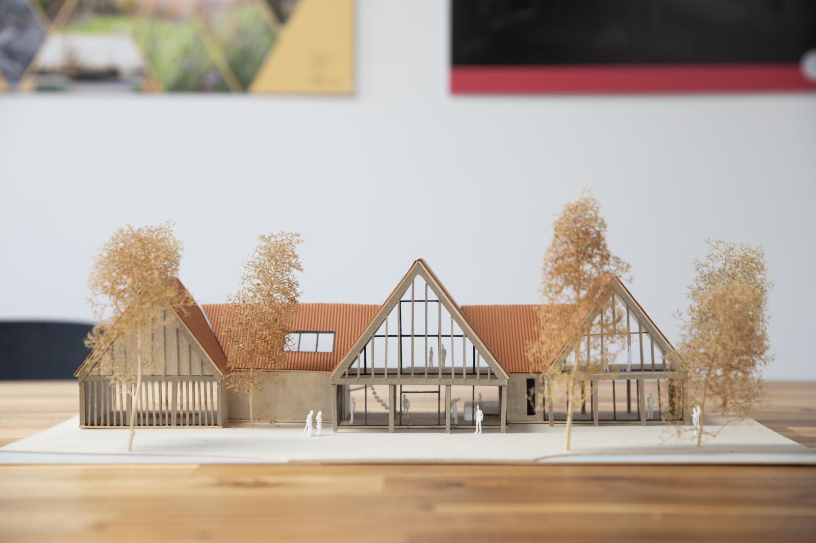 Wellbank Community Hub. Scale 1:100. Sectional model

The physical model was used during client meetings to provide a hands-on representation of the design. It allowed clients to physically interact with the model and look into its interior as well as the external design. This made the scheme easier to understand and visualise compared to a digital model, supporting clearer communication and more informed discussions.

The front facing view of the model indicates the form of the building arranged across a series of pitched roof volumes as well as the façade treatment. As a sectional model, the viewer is also able to understand how the interior levels work and how they are partitioned, including the mezzanine floor. 

Corrugated cardboard, greyboard, mountboard, sea foam trees

Made by Jessica Bell, Part 1 architectural assistant 
